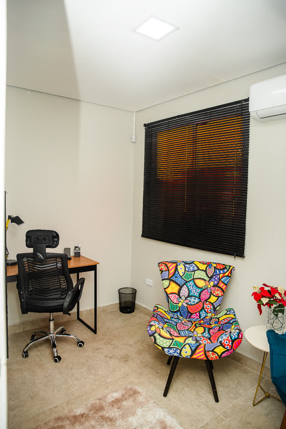 Sala privativa com poltrona estampada e vista para janela