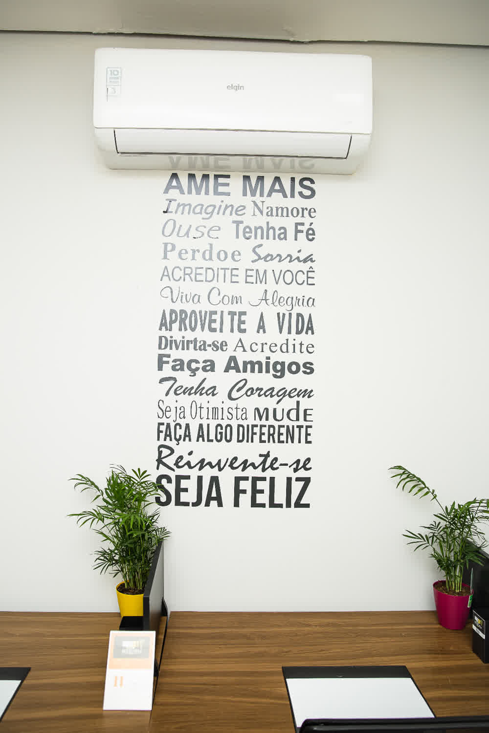 Detalhe do mural com frases inspiradoras e ar-condicionado