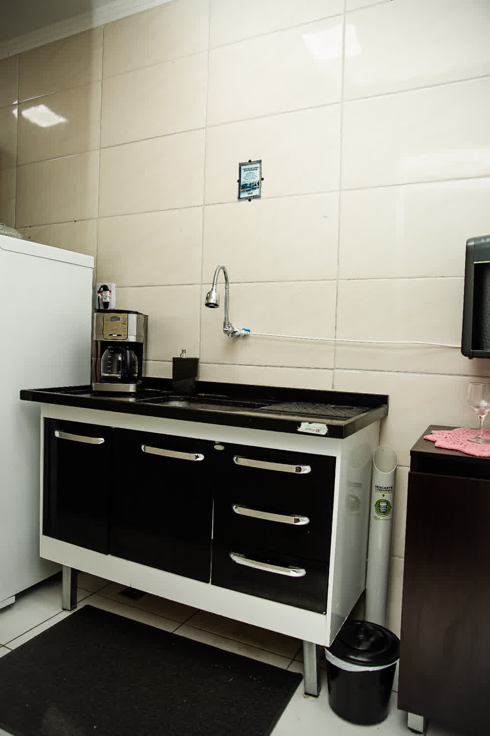 Cozinha compartilhada com cafeteira e pia