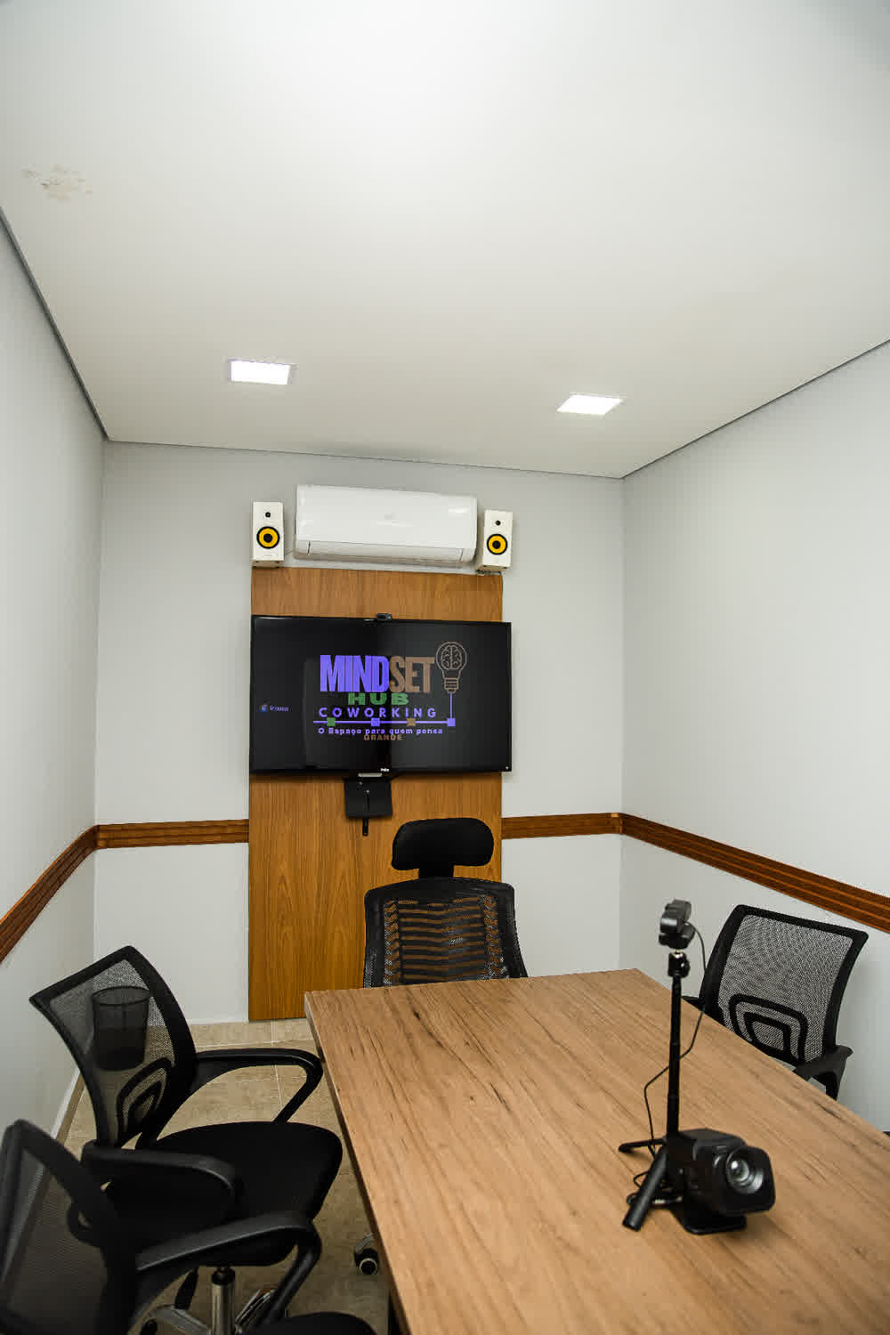 Sala de reunião com TV, câmera e áudio profissional