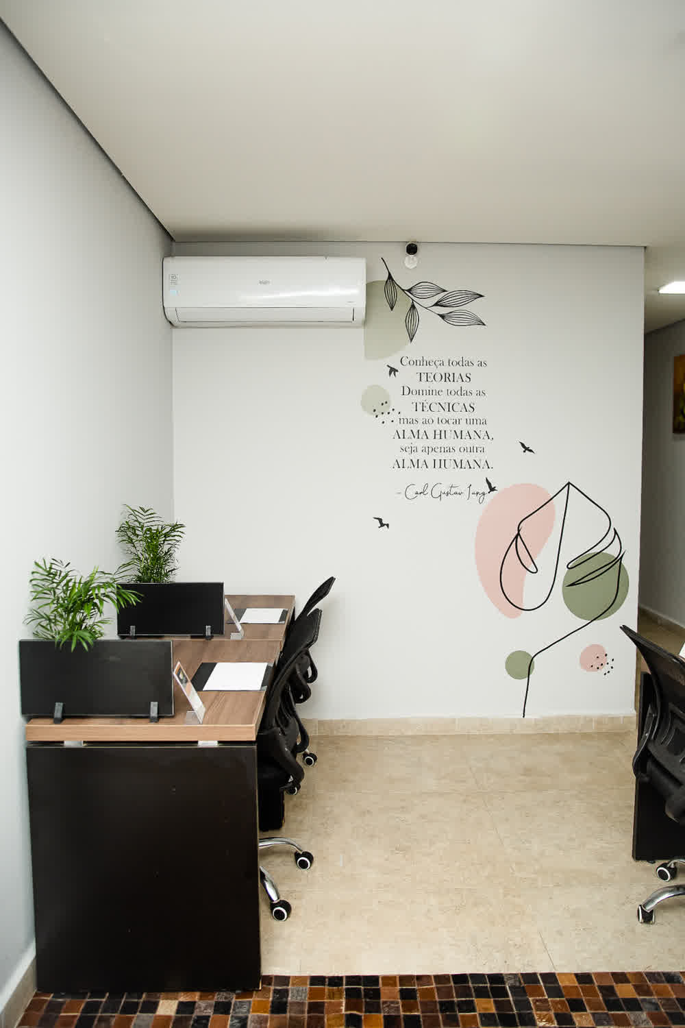 Sala privativa com mural inspiracional sobre teoria, técnica e alma humana