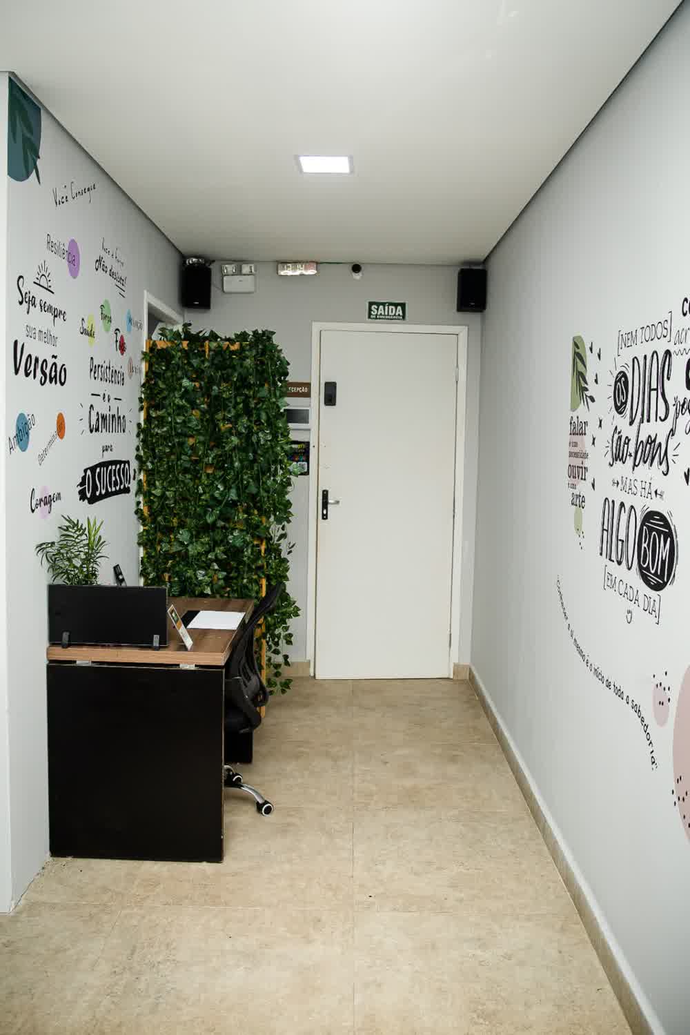Corredor de acesso com recepção e mural motivacional