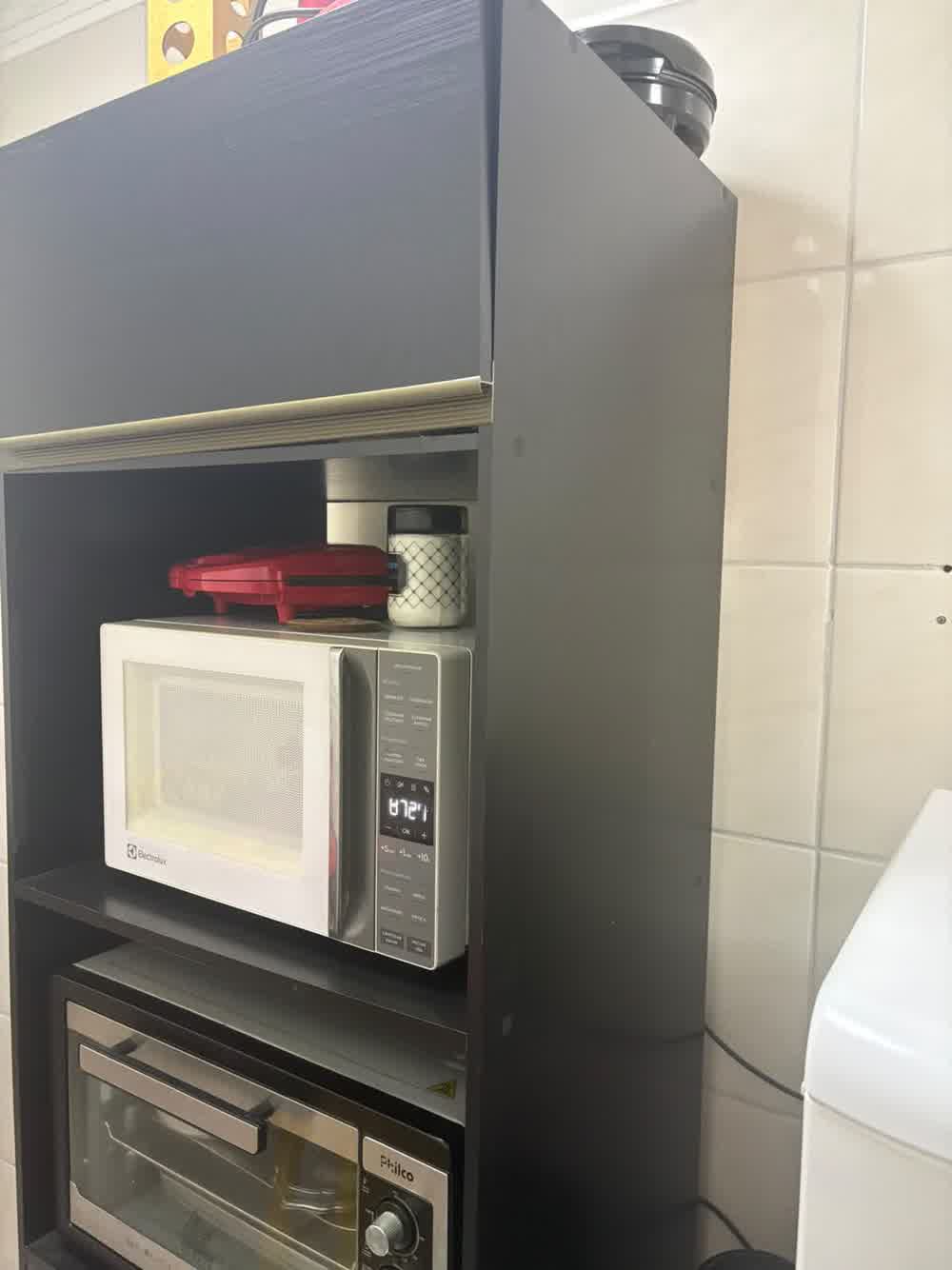 Detalhe do armário com micro-ondas, forno e sanduicheira