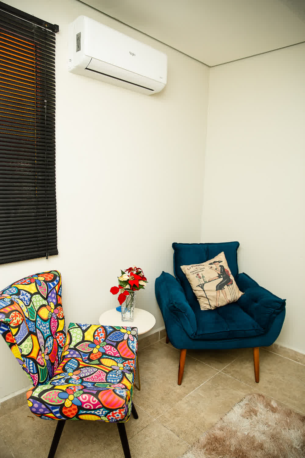 Ambiente com poltrona azul e cadeira estampada colorida